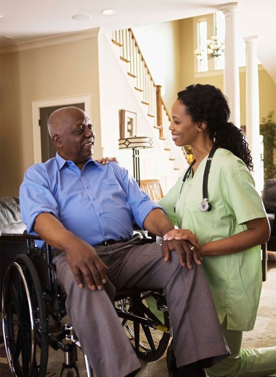 Dedicated caregiver helping an elderly client maintain comfort and independence with elderly care at home near me.